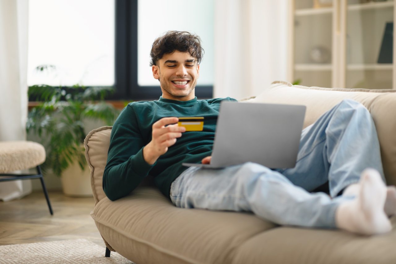Man Holding Credit Card For Payment Shopping Online At Home