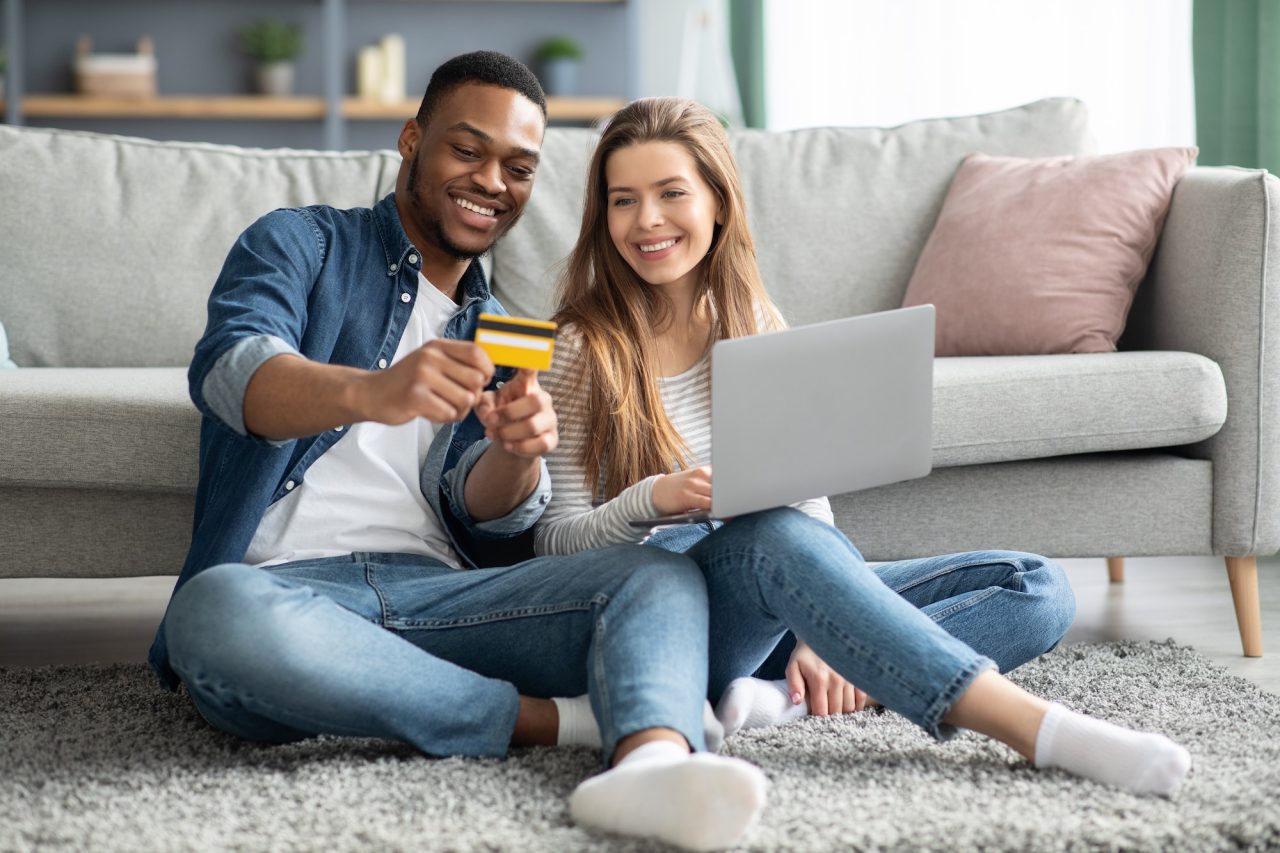 Online Payments. Young Interracial Couple With laptop And Credit Card At Home